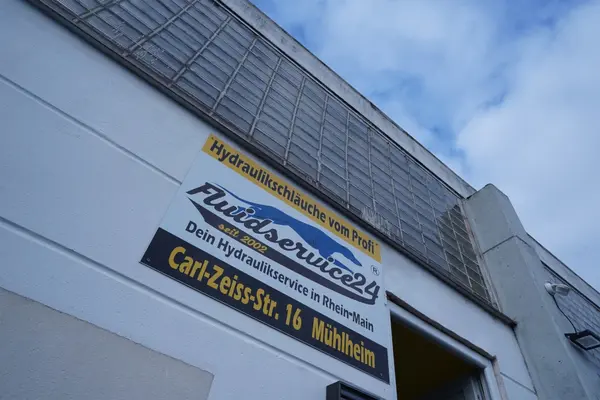 Firmenschild von Fluidservice24 für Hydraulikschläuche an Gebäude in Mühlheim.